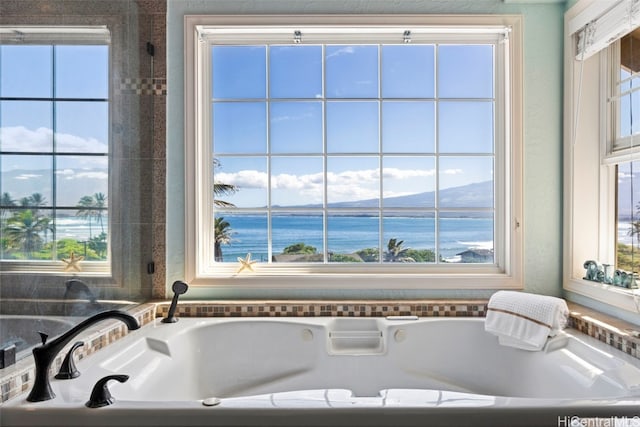 bathroom featuring a tub to relax in and a water and mountain view