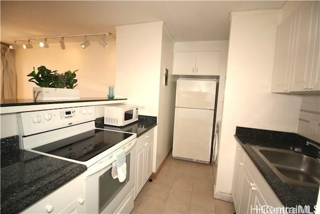 kitchen featuring dark stone countertops, white cabinetry, sink, and white appliances