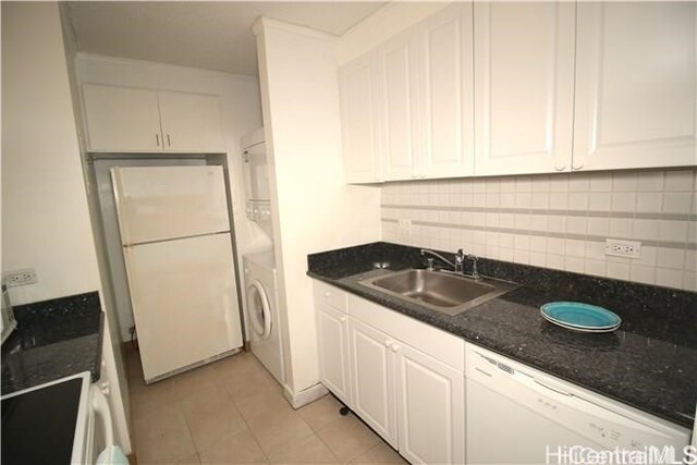 kitchen featuring white appliances, sink, light tile patterned floors, white cabinets, and washer / clothes dryer