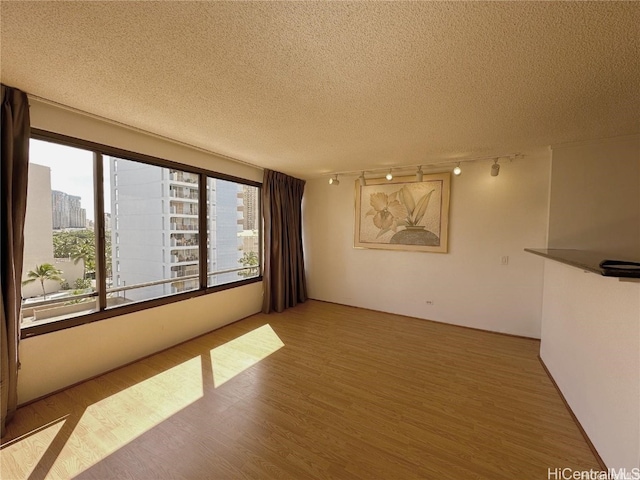 unfurnished room featuring hardwood / wood-style floors and a textured ceiling