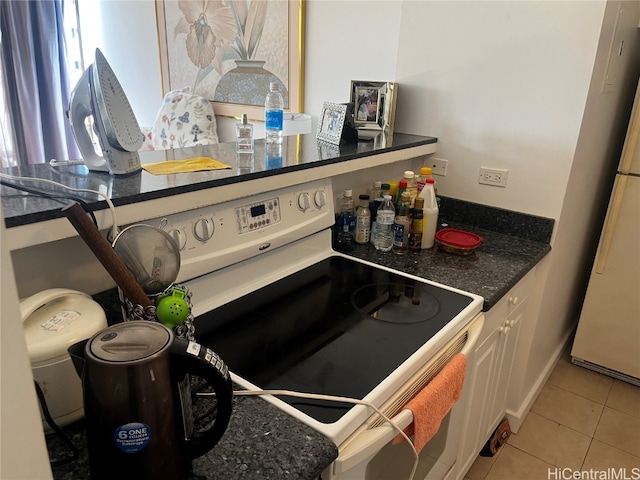 kitchen with white range with electric cooktop, refrigerator, and light tile patterned floors