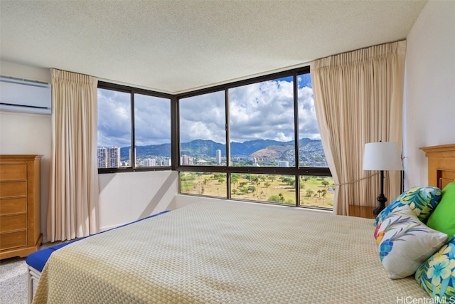 carpeted bedroom featuring a textured ceiling, multiple windows, a mountain view, and a wall mounted air conditioner