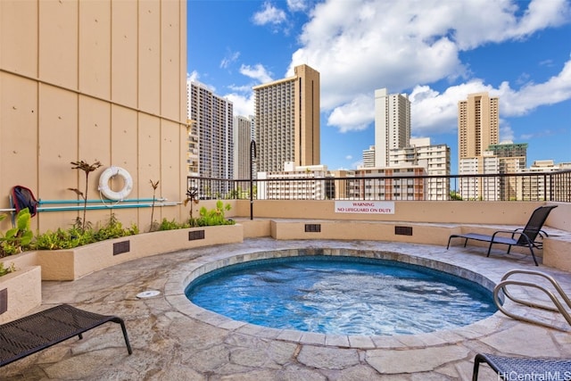 view of swimming pool featuring a hot tub