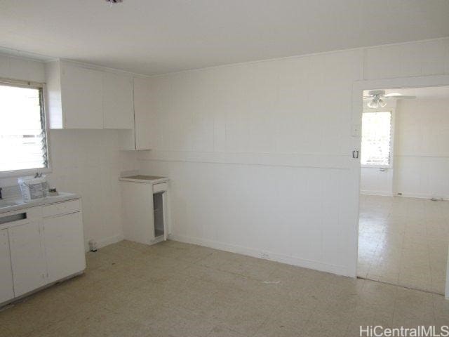91-507 Ewa Beach Rd, Ewa Beach, HI 96706 - kitchen with plenty of natural light, light floors, white cabinetry, and ceiling fan