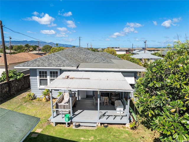 91-507 Ewa Beach Rd, Ewa Beach, HI 96706 - rear view of house with a shingled roof, a deck with mountain view, and a lawn