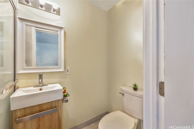 bathroom featuring wood-type flooring, vanity, and toilet