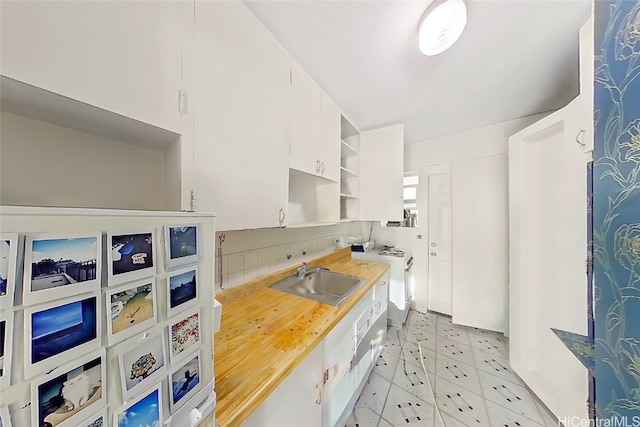 kitchen featuring white cabinetry, sink, and washer / dryer