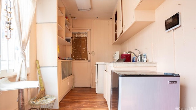 kitchen with hardwood / wood-style floors and fridge