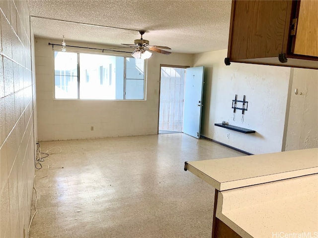 interior space with ceiling fan and a textured ceiling