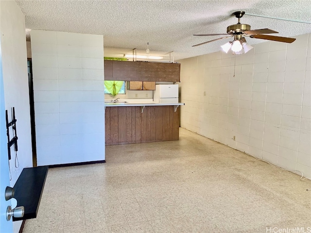 kitchen featuring kitchen peninsula, a textured ceiling, white fridge, and ceiling fan