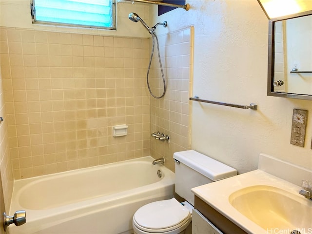 full bathroom with vanity, tiled shower / bath combo, and toilet