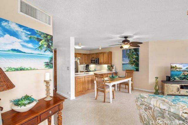 dining area with baseboards, a ceiling fan, visible vents, and light colored carpet