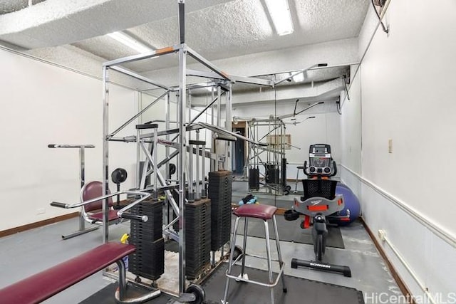 workout area with a textured ceiling and baseboards