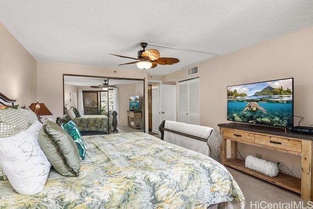 bedroom featuring a textured ceiling, ceiling fan, carpet flooring, and visible vents