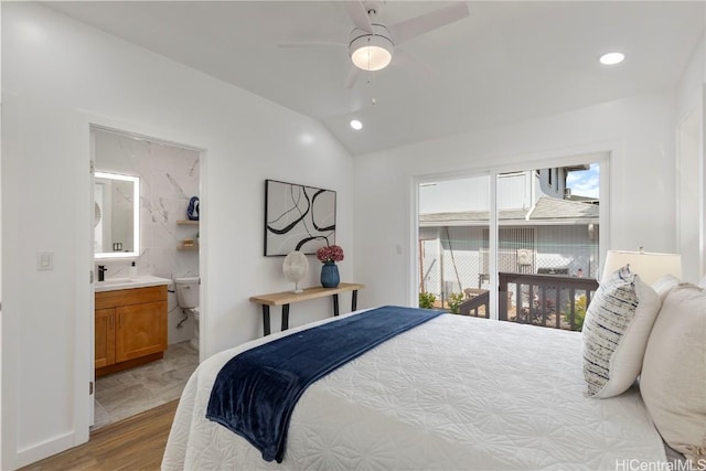 bedroom featuring ensuite bathroom, sink, vaulted ceiling, light hardwood / wood-style flooring, and ceiling fan