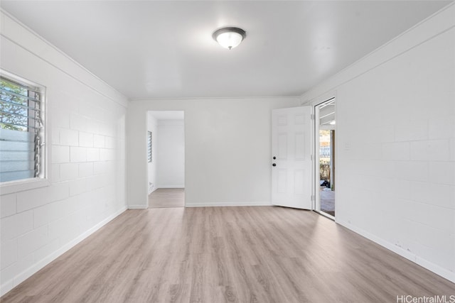 unfurnished room featuring light hardwood / wood-style flooring, a wealth of natural light, and crown molding