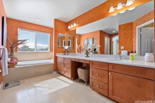 bathroom with tile patterned floors, tiled tub, and vanity