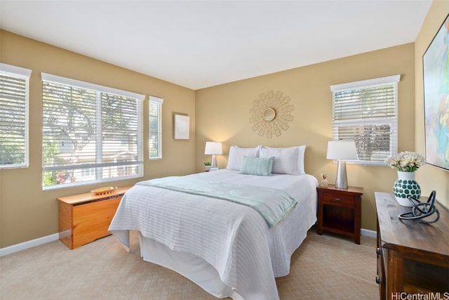 bedroom with light carpet and multiple windows