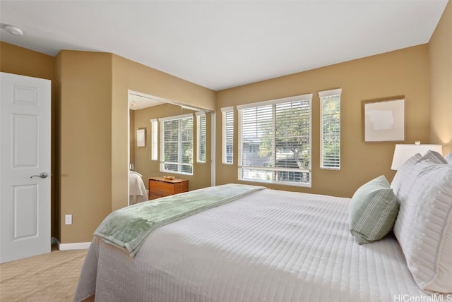 bedroom with multiple windows and light colored carpet