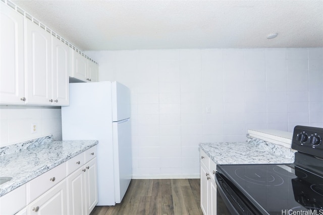 kitchen featuring a textured ceiling, dark hardwood / wood-style floors, black electric range oven, and white cabinetry