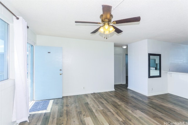 empty room with a textured ceiling, dark hardwood / wood-style flooring, and ceiling fan