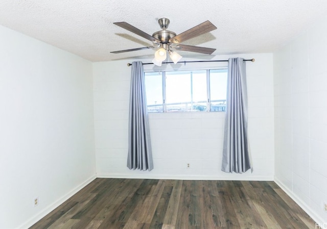 empty room with a textured ceiling, dark hardwood / wood-style flooring, and ceiling fan