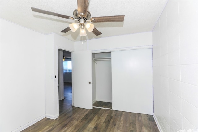 unfurnished bedroom featuring dark hardwood / wood-style floors, a textured ceiling, and a closet