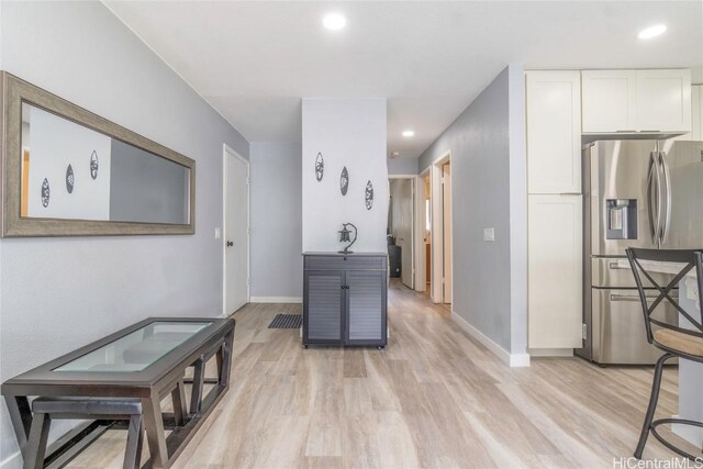 interior space with recessed lighting, light wood-style floors, white cabinetry, stainless steel fridge, and baseboards