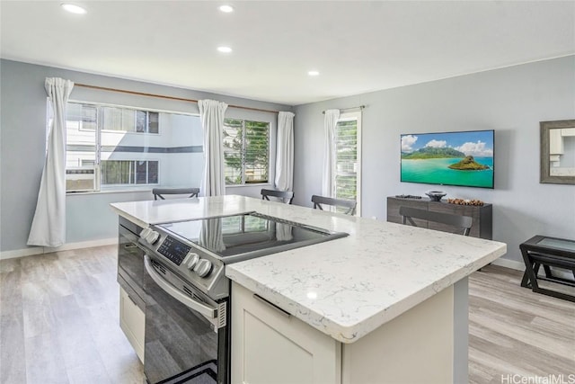 kitchen featuring baseboards, light wood-style flooring, light stone countertops, stainless steel electric stove, and recessed lighting