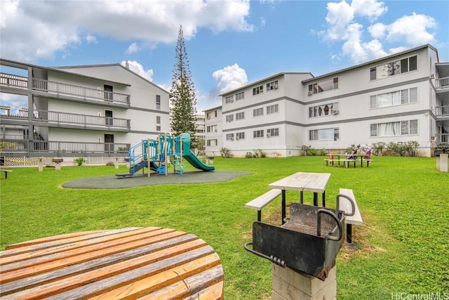 view of home's community featuring playground community and a lawn