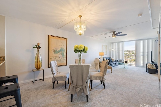 dining area featuring ceiling fan with notable chandelier and light carpet