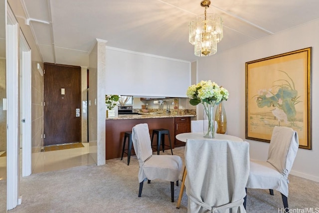 carpeted dining space with an inviting chandelier and ornamental molding