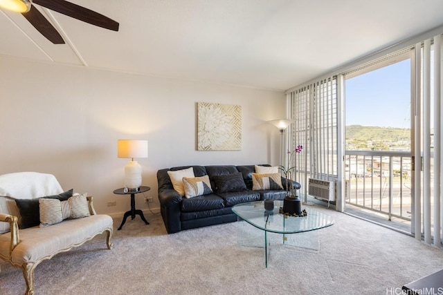 carpeted living room featuring ceiling fan and an AC wall unit