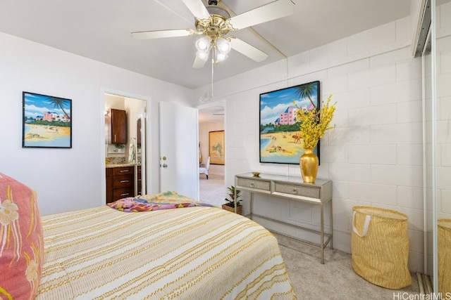 bedroom featuring ceiling fan, light carpet, and connected bathroom