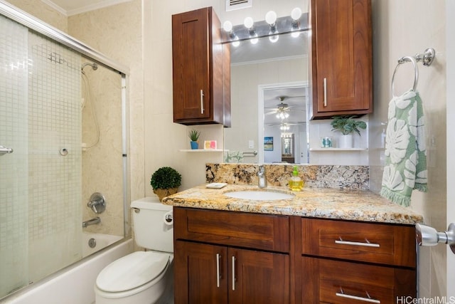 full bathroom with ceiling fan, bath / shower combo with glass door, toilet, vanity, and ornamental molding