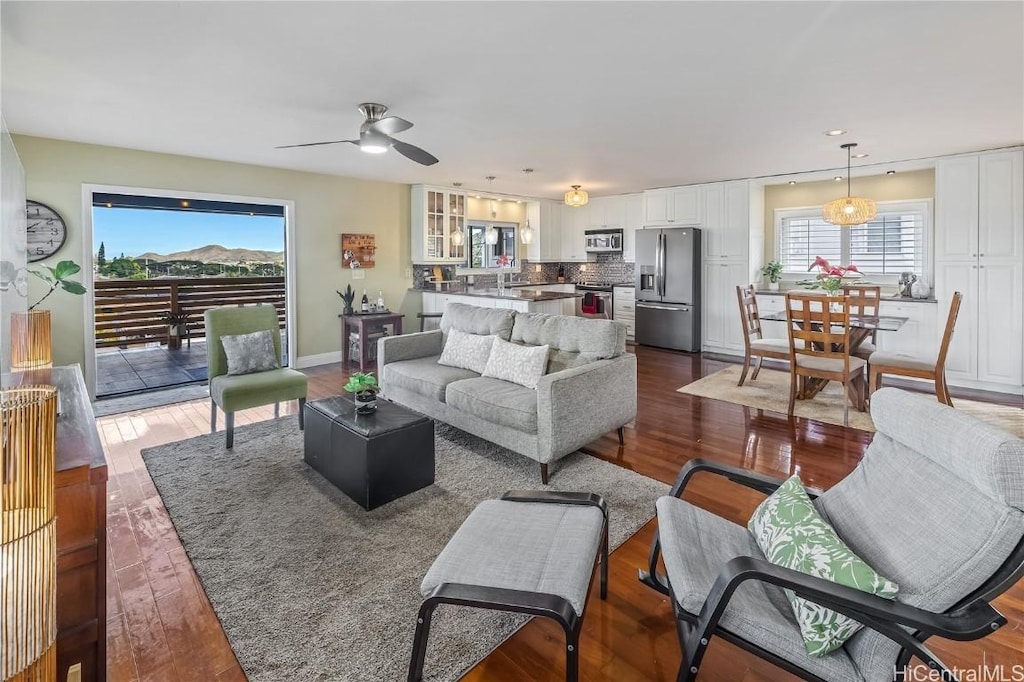 living room with dark hardwood / wood-style flooring, plenty of natural light, and ceiling fan