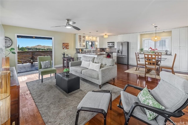 living room with dark hardwood / wood-style flooring, plenty of natural light, and ceiling fan