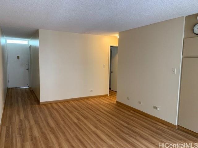 unfurnished room featuring wood-type flooring and a textured ceiling