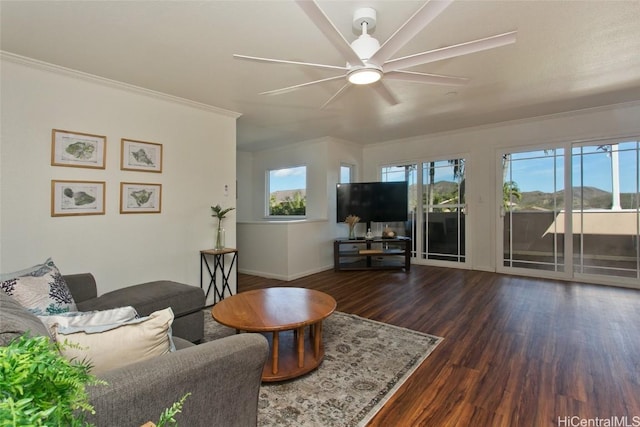 living room with crown molding, dark wood-type flooring, and ceiling fan