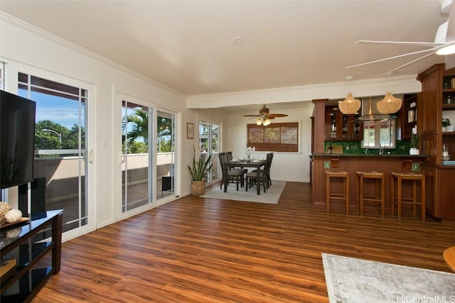 interior space featuring dark wood-type flooring, ceiling fan, crown molding, and a wealth of natural light