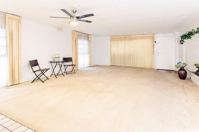 living area featuring carpet floors and ceiling fan