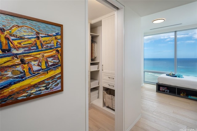 corridor with wood finished floors and a water view