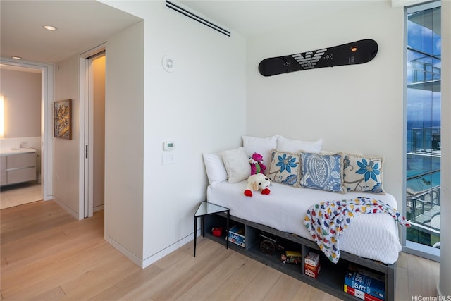 bedroom with wood finished floors, recessed lighting, and baseboards