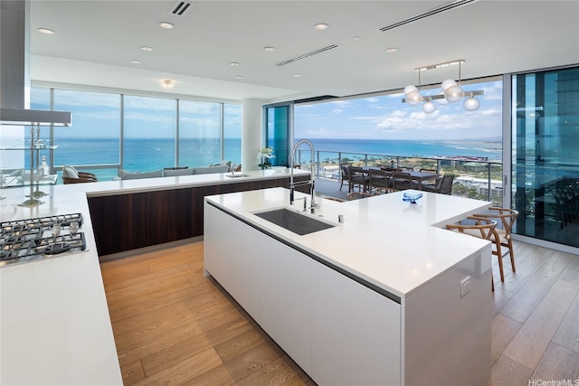 kitchen featuring white cabinets, a sink, light wood-style floors, light countertops, and modern cabinets