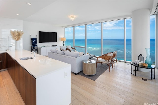 living room with expansive windows, light wood-style flooring, and recessed lighting