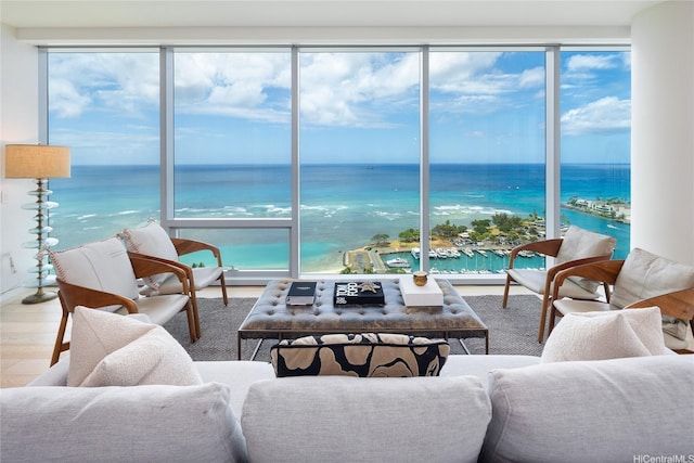 living room featuring a wealth of natural light, wood finished floors, and a water view