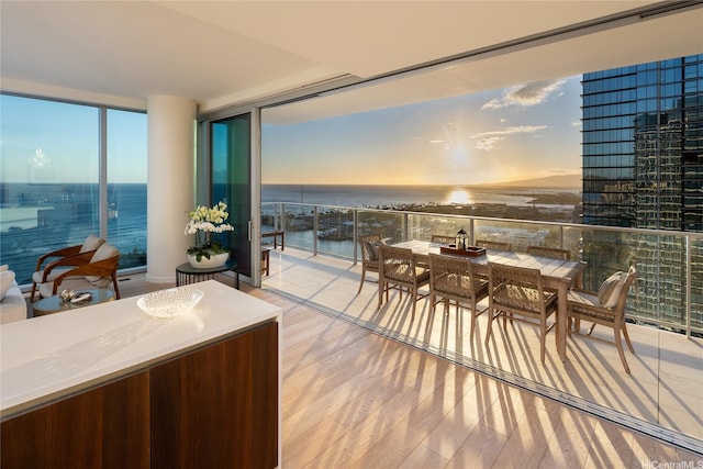 dining area featuring a water view, floor to ceiling windows, and wood finished floors