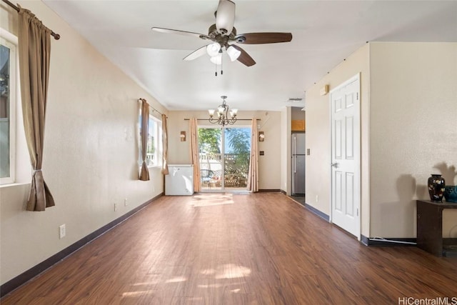 unfurnished room with dark wood-type flooring and ceiling fan with notable chandelier