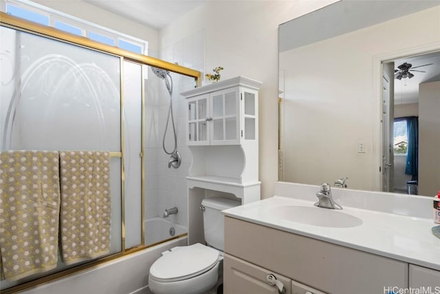 full bathroom with ceiling fan, vanity, bath / shower combo with glass door, and toilet