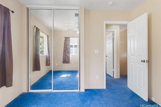 unfurnished bedroom featuring carpet and a closet